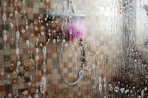 A dirty shower door after a shower